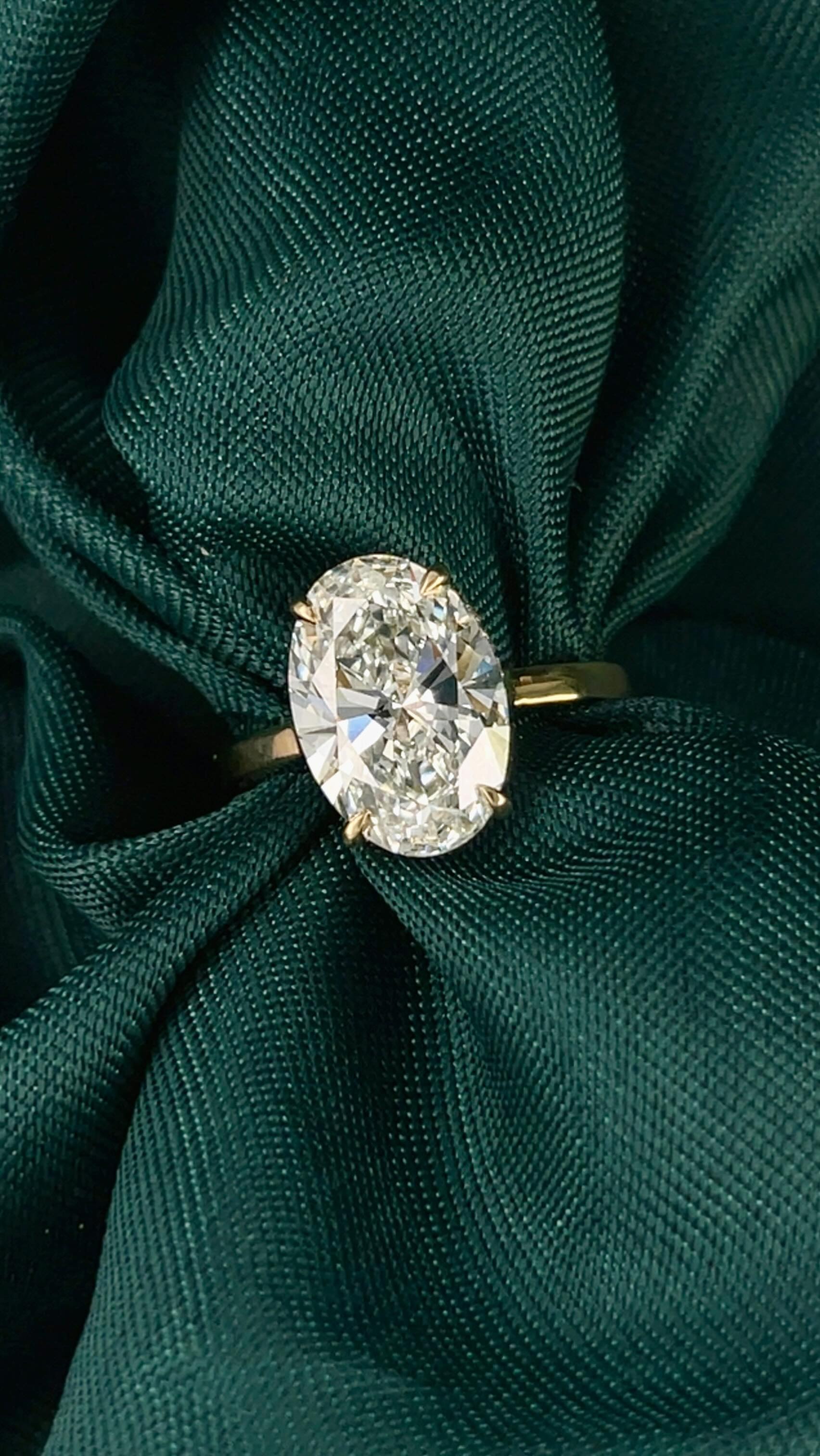 Oval diamond engagement ring on fabric - custom designed by Green Jewelers