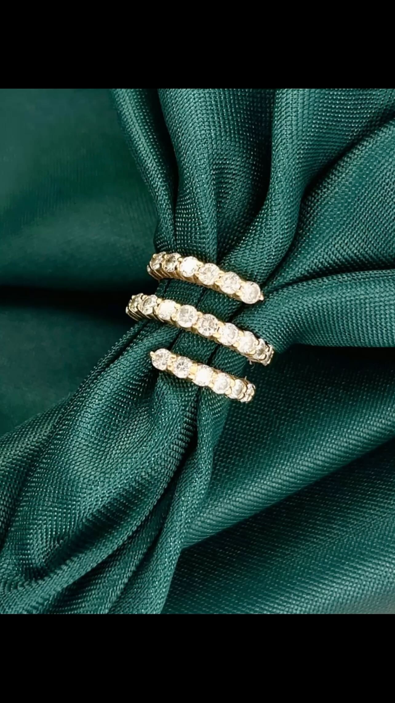 Stacked diamond eternity bands and wedding rings on fabric